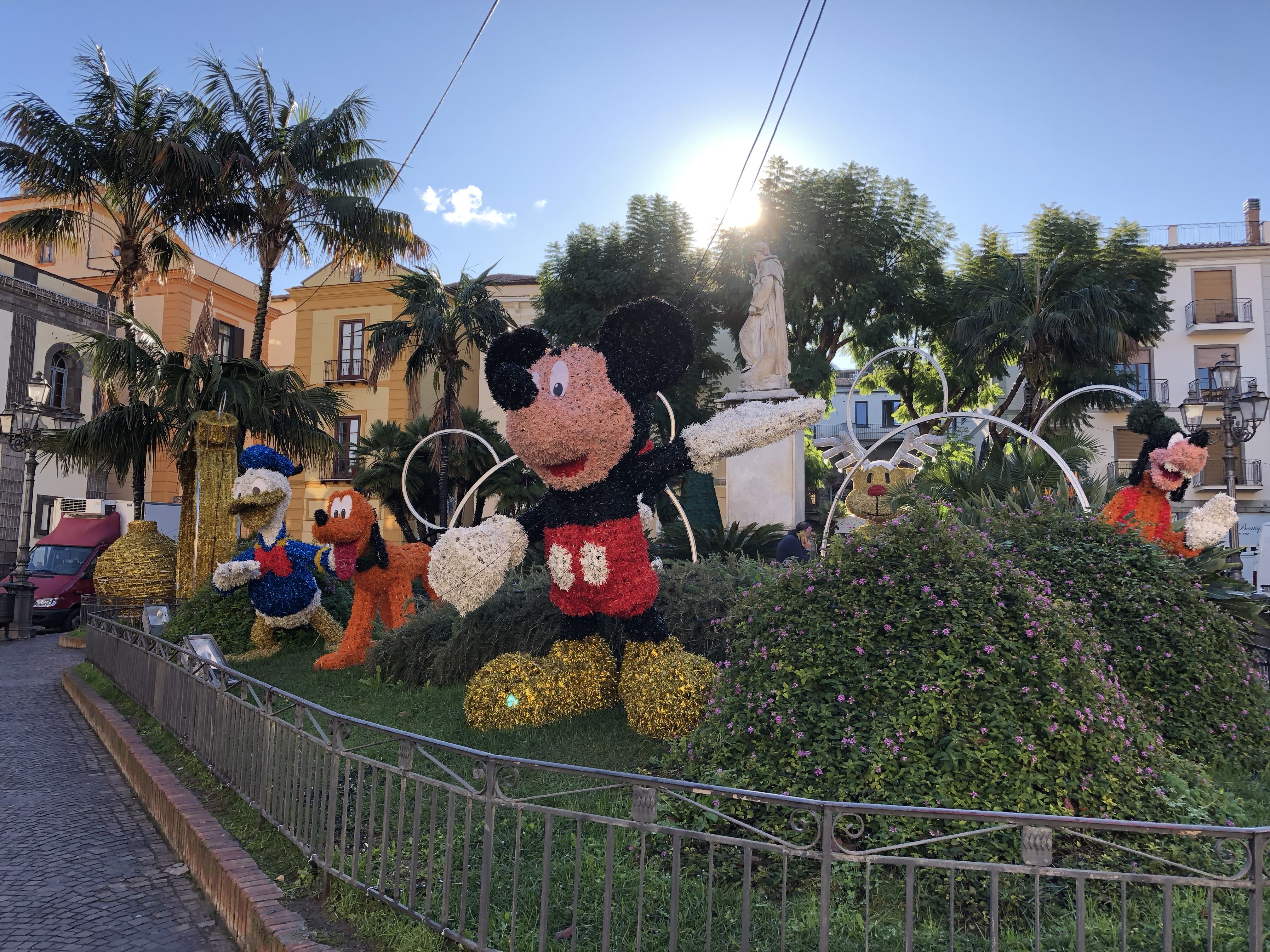 A fenced garden in Sorrento surrounded by cobbled pathways.  Completely non-infringing figures of Mickey Mouse, Donald Duck, Pluto and Goofy can be seen among the bushes.