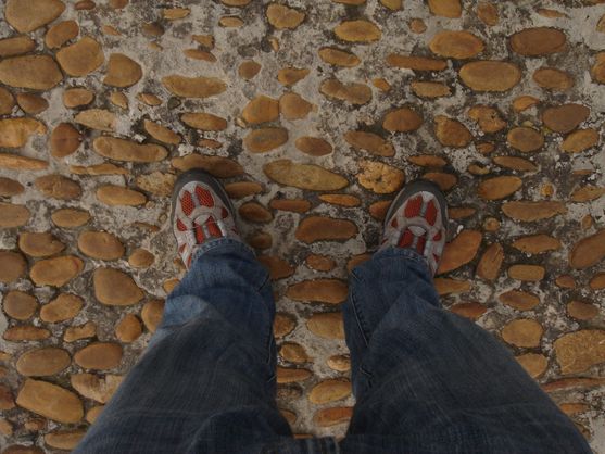 Looking down my legs: I'm wearing jeans and sturdy walking shoes,  and standing on the pebbly surface of what turns out to be the  bridge at Avignon.