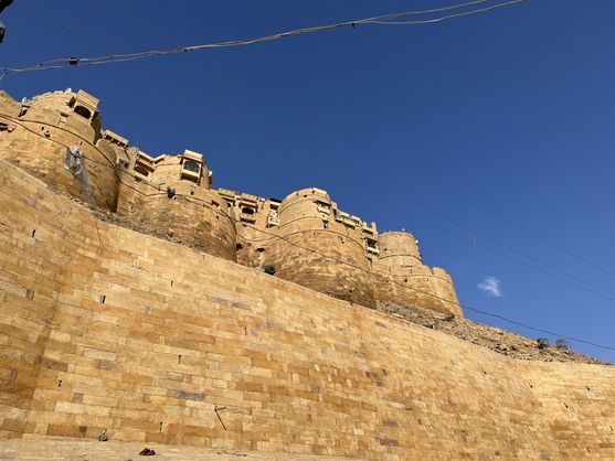 A yellow sandstone wall with a few turrets perched on top of it