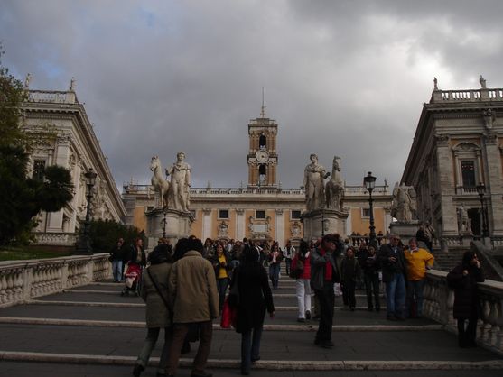 An old ramp with whited concrete railings leads up to an ornate museum building with a clock tower. In front of it, on the left, is a statue of a man mounted on horseback.