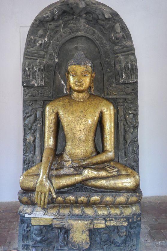 A golden statue of the Buddha in the enlightenment pose, touching his right hand to the ground