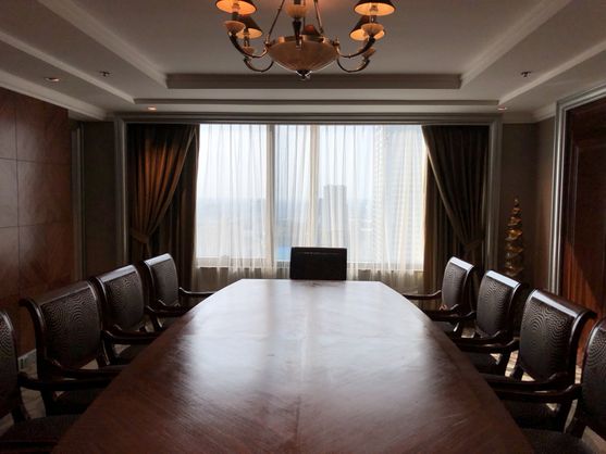 A wood-panelled boardroom. Part of the same expensive hotel suite.