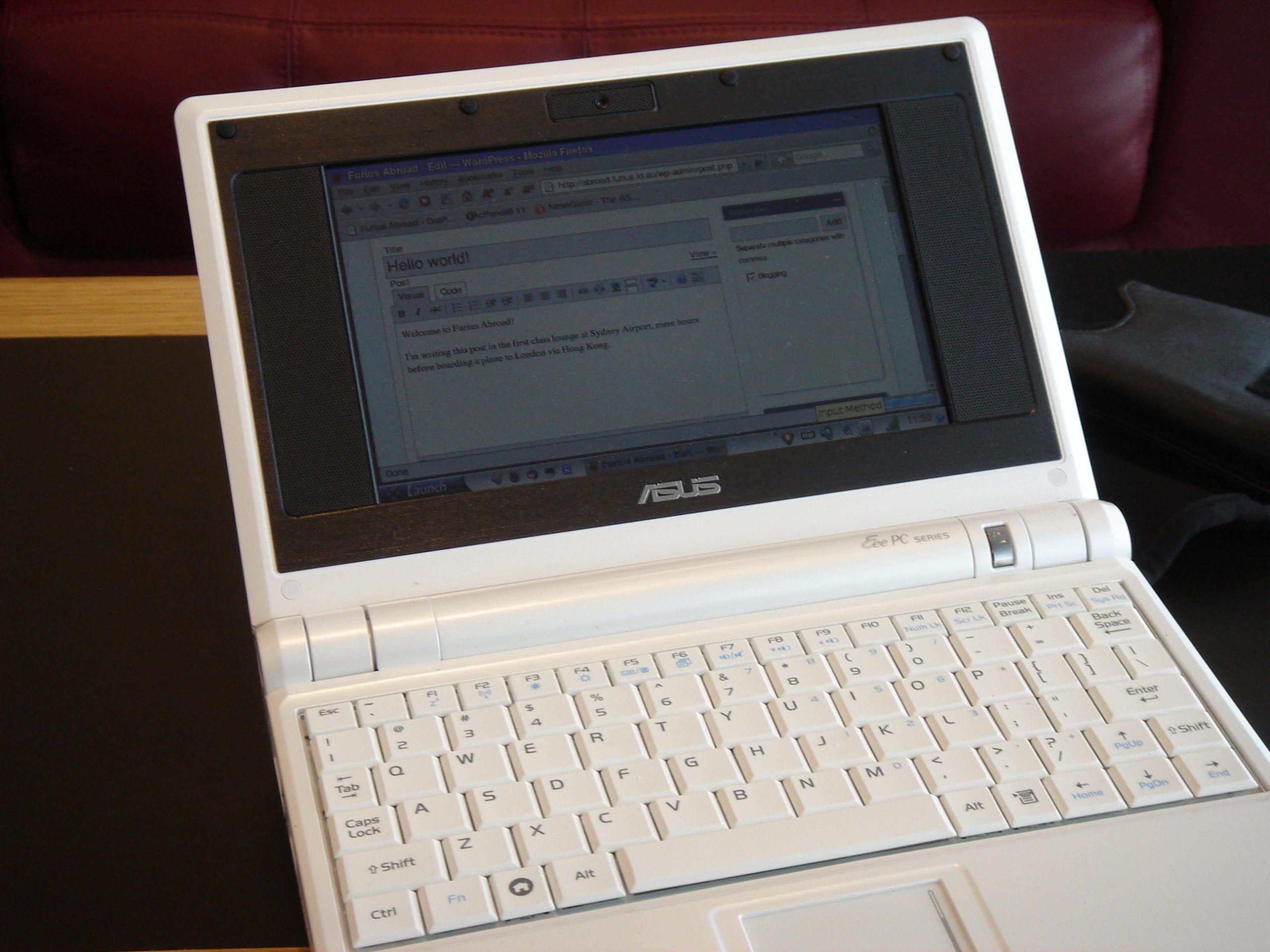 A tiny white plastic laptop. The browser is open on the WordPress admin page of this blog, showing a post being edited.
