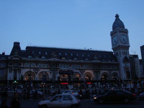It's dusk. We're looking at the Gare de Lyon, an ornate nineteenth-century train station dominated by a tall clock tower.